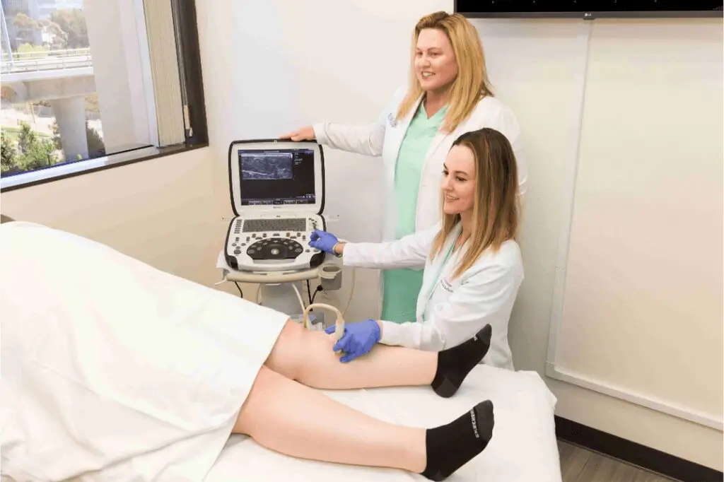 Healthcare providers performing leg ultrasound in clinic